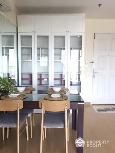 Modern dining area with sleek glass cabinets and stylish wooden chairs