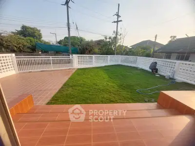 Spacious garden with tiled patio in suburban home