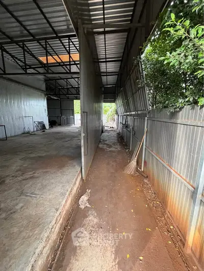 Spacious industrial warehouse with high ceilings and metal walls, ideal for storage or manufacturing.