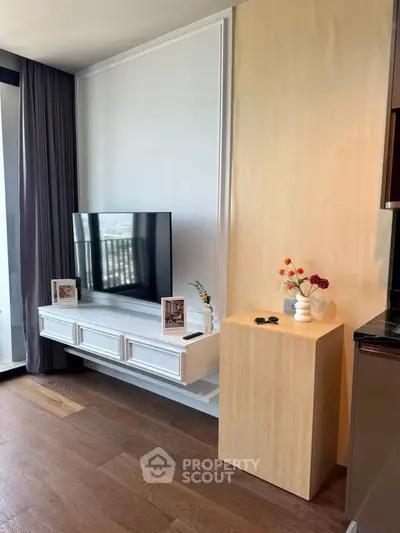 Modern living room with sleek TV setup and stylish decor in a contemporary apartment.
