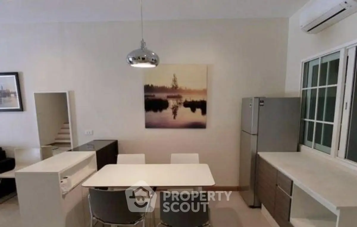 Modern dining area with sleek furniture and stylish lighting in a contemporary home.