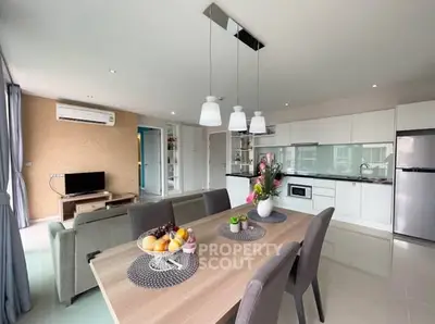 Modern open-plan kitchen and living area with stylish dining table and contemporary decor.