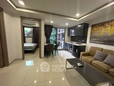 Modern open-plan living room with kitchen and dining area, featuring sleek design and natural light.