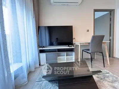 Modern living room with sleek furniture and large TV, perfect for relaxation.