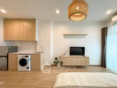 Modern studio apartment with open layout, featuring stylish kitchen and cozy living area.