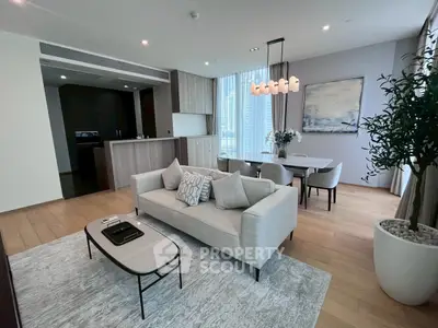 Spacious modern living room with elegant decor and open dining area, featuring large windows and stylish furnishings.
