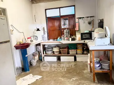 Cozy kitchen with essential appliances and storage solutions, featuring a microwave, fridge, and ample counter space.