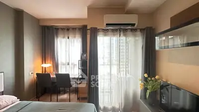 Modern bedroom with study area, large windows, and stylish decor in a high-rise apartment.