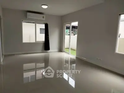 Spacious empty living room with glossy floors and large windows