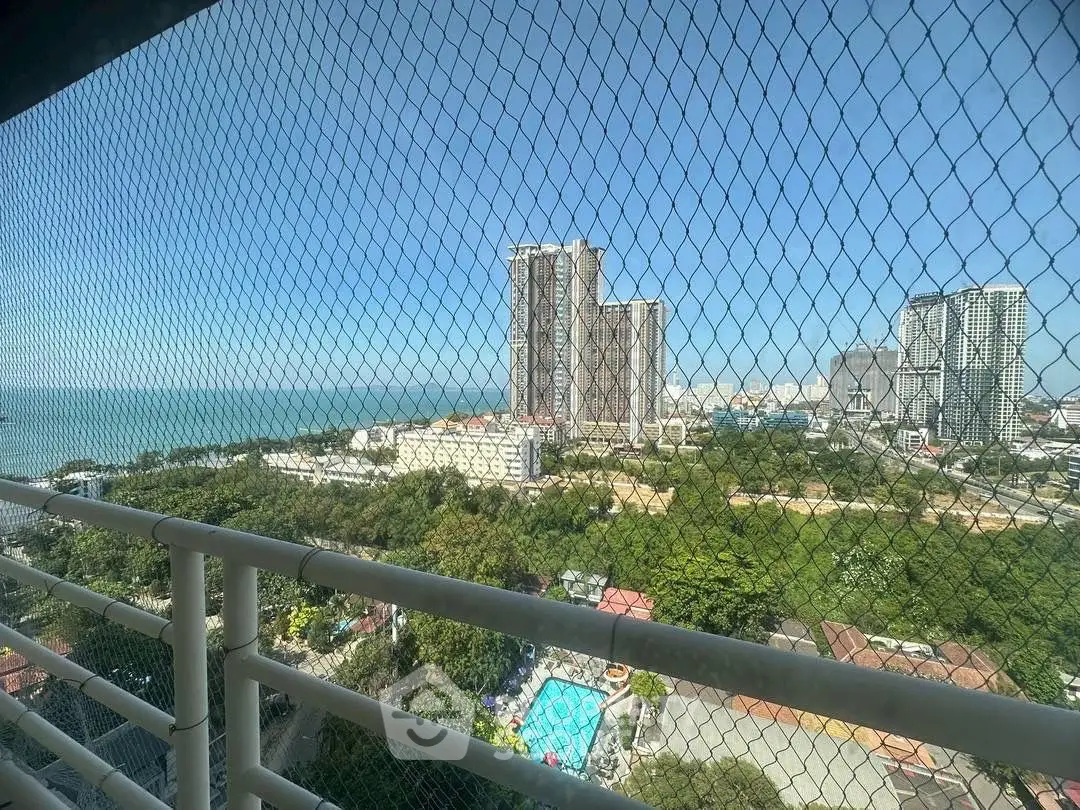 Stunning high-rise view of cityscape and ocean from a secure balcony, perfect for urban living.