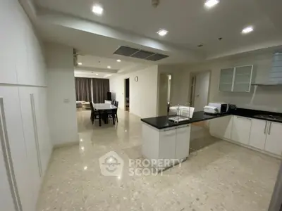 Spacious open-layout kitchen and dining area with modern appliances and elegant lighting.