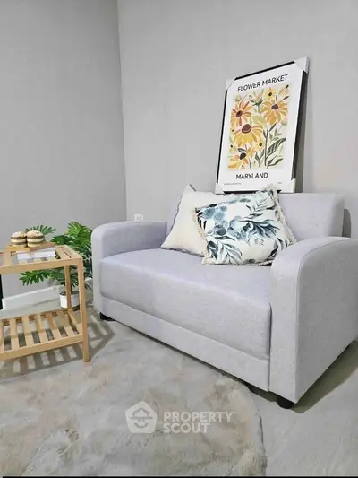 Cozy living room with stylish gray sofa and floral decor, perfect for relaxation.