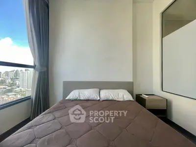 Modern bedroom with city view, featuring a cozy bed and large window for natural light.