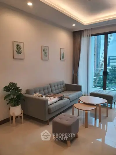 Modern living room with stylish furniture and large window offering city view.