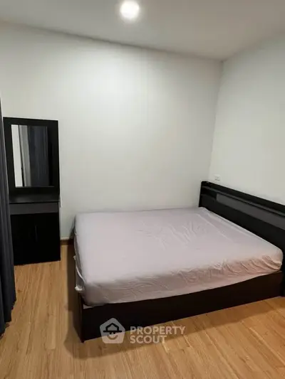 Cozy bedroom with modern furniture and wooden flooring, perfect for relaxation.