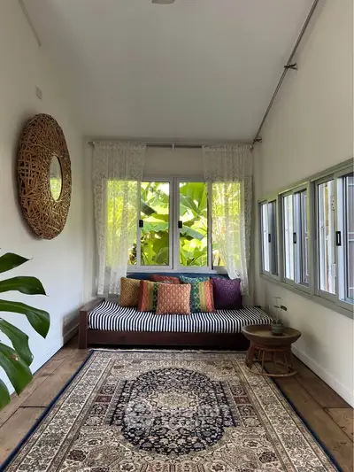 Charming sunlit room with cozy daybed, vibrant cushions, and elegant decor, perfect for relaxation and style.