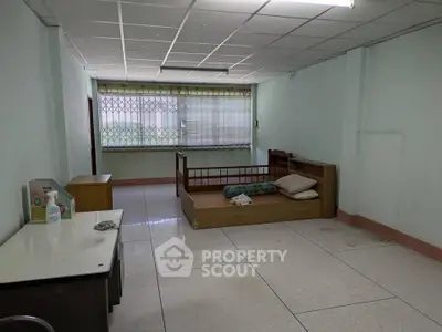 Spacious unfurnished room with large window and simple decor