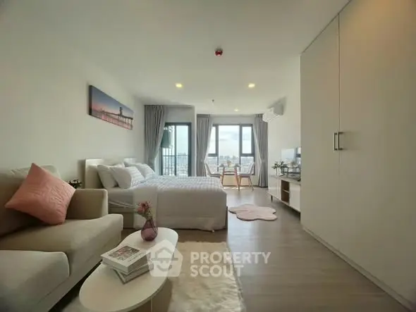 Modern studio apartment with cozy living area and stunning city view