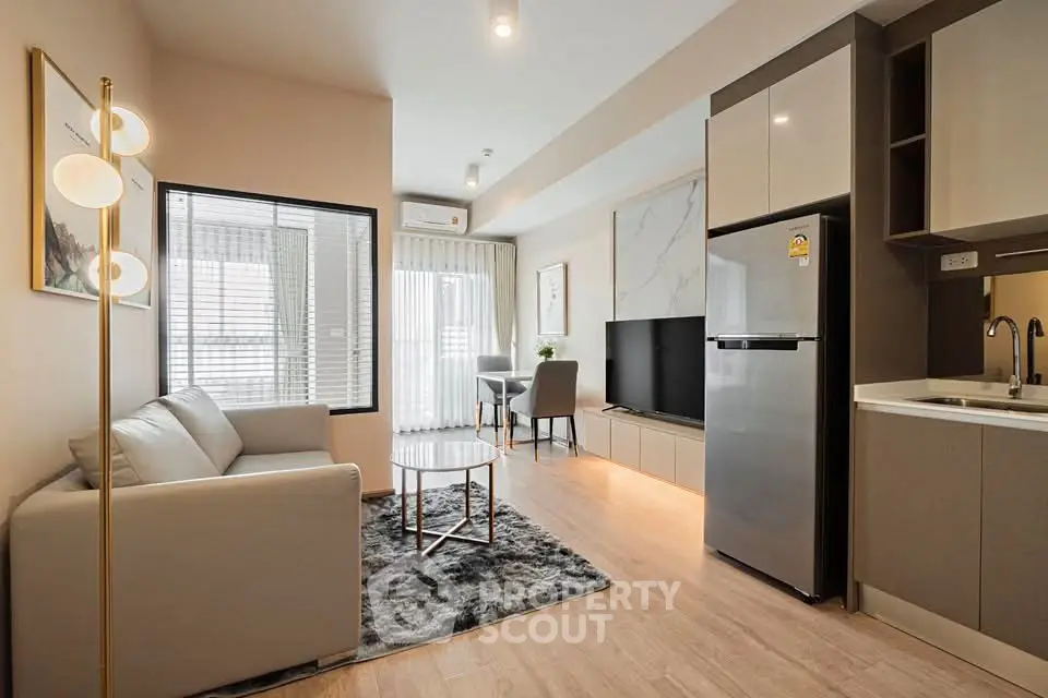 Modern living room with sleek furniture and open kitchen layout in a stylish apartment.