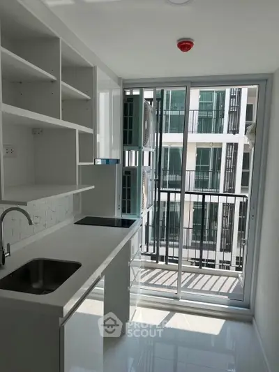 Modern kitchen with sleek white cabinetry and large window view