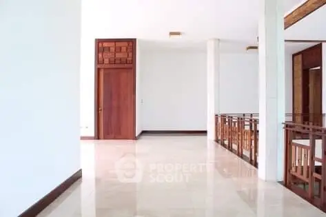 Spacious hallway with elegant wooden accents and polished floors in modern home.