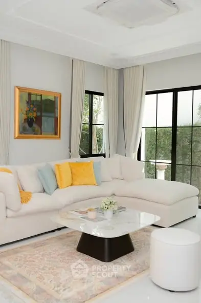 Elegant living room with modern decor, large windows, and cozy seating area.