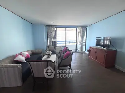 Spacious living room with elegant furniture and large windows offering city views.