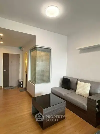 Modern living room with sleek furniture and wooden flooring in a cozy apartment.