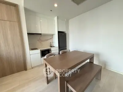 Modern kitchen with dining area, featuring sleek cabinetry and integrated appliances.