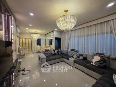 Luxurious living room with elegant chandeliers and plush sectional sofa in modern home.