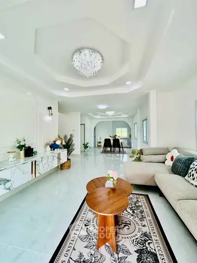 Luxurious open-plan living room with elegant chandelier and modern decor