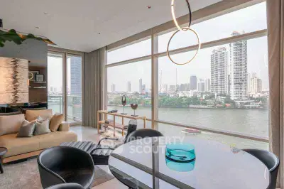 Luxurious living room with stunning river view and modern decor in high-rise apartment.