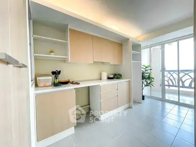 Modern kitchen with open layout and balcony access, featuring sleek cabinetry and ample natural light.