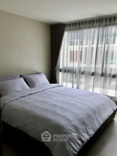 Modern bedroom with large window and elegant curtains in a stylish apartment.