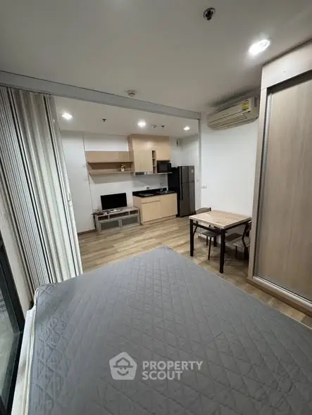 Modern studio apartment with open layout, featuring a cozy living area, compact kitchen, and dining space.