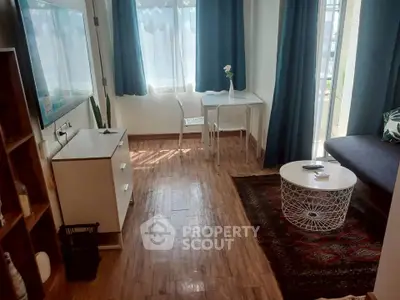 Charming living room with natural light, modern decor, and cozy seating area, perfect for relaxation.