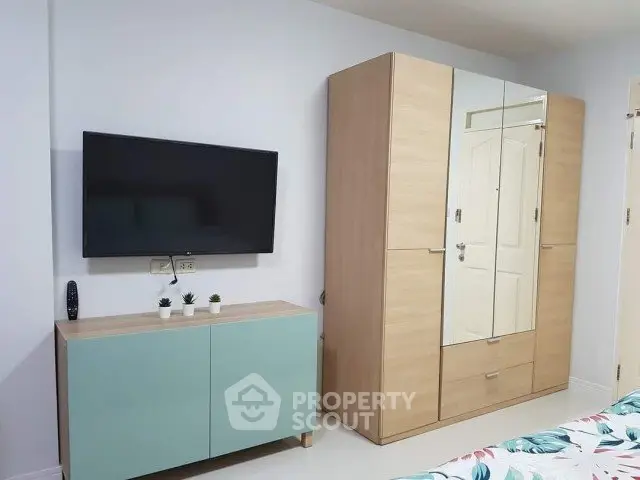 Modern bedroom with sleek TV setup and stylish wardrobe