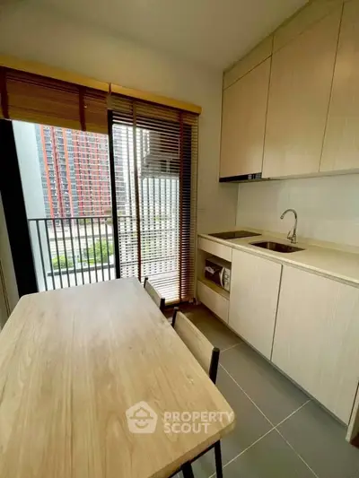 Modern kitchen with sleek cabinetry and balcony view in urban apartment