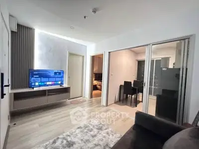 Modern living room with open layout and sleek design, featuring a cozy seating area and dining space.