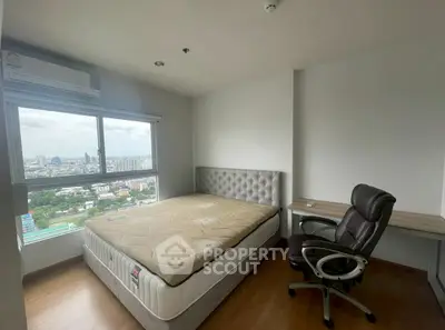 Modern bedroom with city view, featuring a comfortable bed and office chair, perfect for urban living.