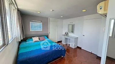 Bright bedroom with large windows and modern decor, featuring a cozy bed and stylish furnishings.