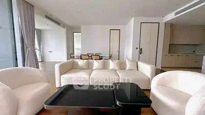 Luxurious modern living room with elegant white furniture and open kitchen layout