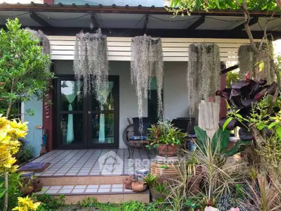 Charming garden entrance with lush greenery and cozy seating area