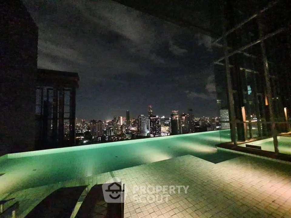 Stunning rooftop pool with breathtaking city skyline view at night, perfect for luxury urban living.