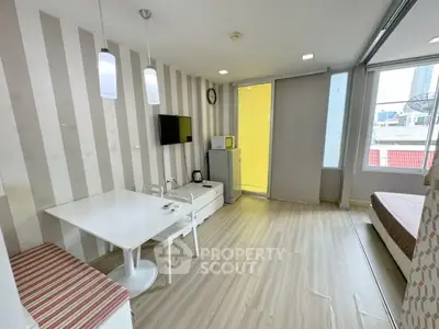 Modern living room with stylish decor and natural light, featuring a dining area and cozy seating.