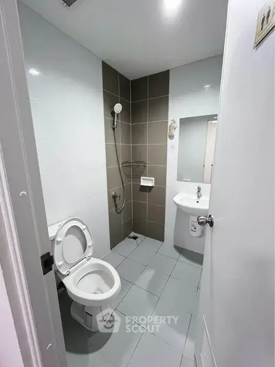 Modern bathroom with sleek tiles and contemporary fixtures in a real estate property.