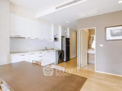Modern kitchen with sleek white cabinets and integrated appliances in open layout.