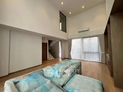 Spacious modern living room with high ceilings and large windows