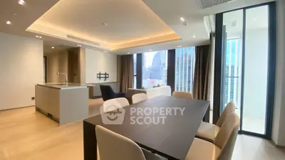 Luxurious modern living room with open kitchen and city view, featuring elegant dining area and stylish lighting.