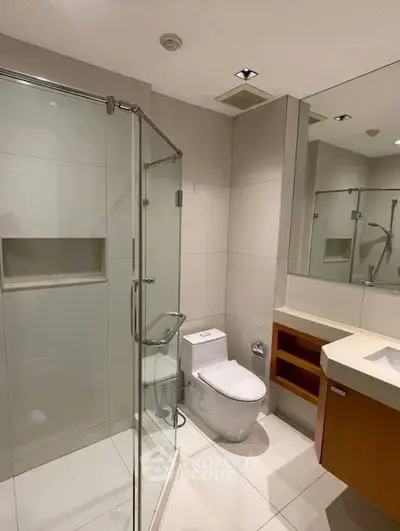 Modern bathroom with glass shower and sleek fixtures in a contemporary apartment.